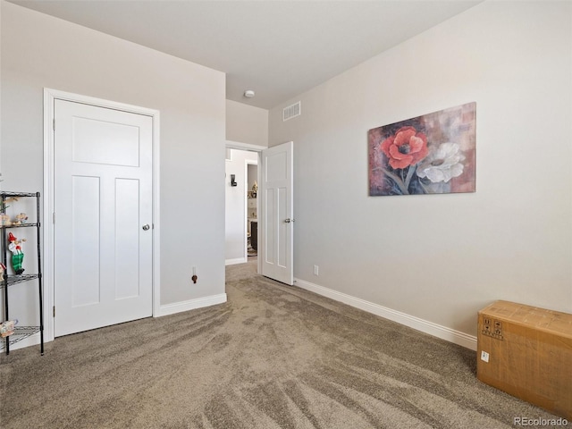 unfurnished bedroom with carpet floors, visible vents, and baseboards