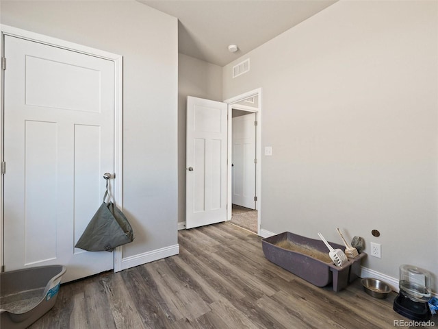 interior space featuring wood finished floors, visible vents, and baseboards