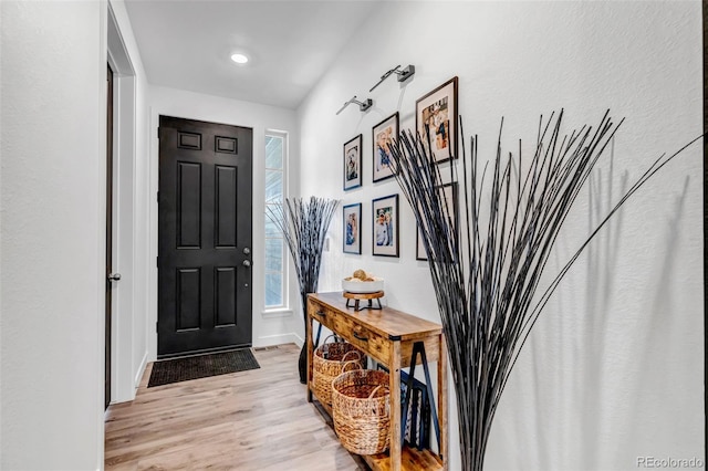 foyer entrance featuring baseboards and light wood-style flooring