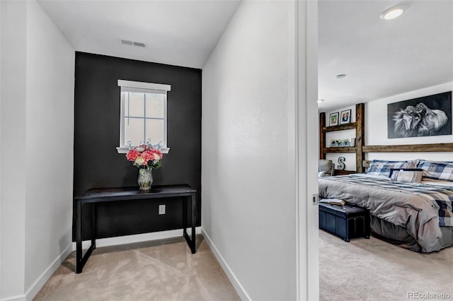 hallway featuring carpet flooring, baseboards, and visible vents