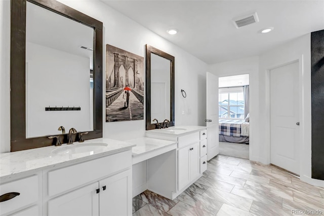 ensuite bathroom featuring visible vents, two vanities, a sink, and ensuite bath