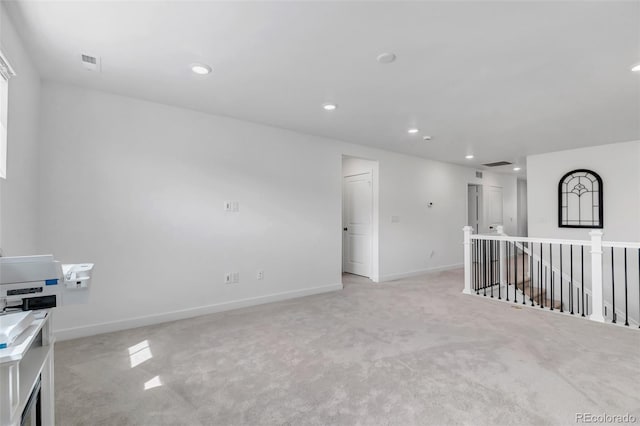 unfurnished room featuring visible vents, recessed lighting, baseboards, and light carpet