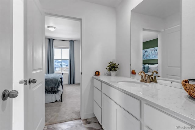 bathroom featuring connected bathroom, baseboards, and vanity