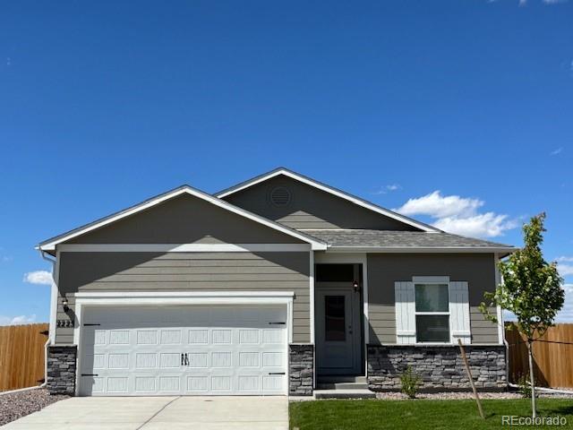 2225 Alyssa St, Fort Lupton, CO 80621 - view of front of property featuring stone siding, driveway, and an attached garage