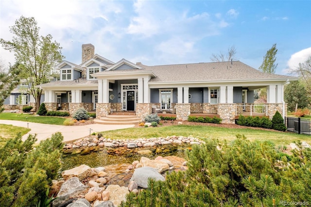 5425 S University Blvd, Greenwood Village, CO 80121 - view of front of house featuring covered porch, stone siding, a chimney, and a shingled roof