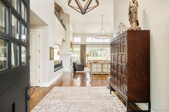 5425 S University Blvd, Greenwood Village, CO 80121 - entrance foyer featuring a chandelier, wood finished floors, a fireplace, a high ceiling, and baseboards