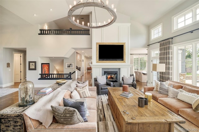 5425 S University Blvd, Greenwood Village, CO 80121 - living room with high vaulted ceiling, light wood-style floors, a chandelier, a glass covered fireplace, and baseboards