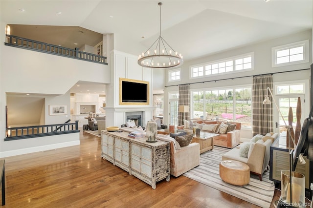 5425 S University Blvd, Greenwood Village, CO 80121 - living area with light wood-style floors, high vaulted ceiling, a chandelier, and healthy amount of natural light