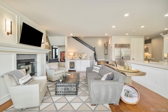 5425 S University Blvd, Greenwood Village, CO 80121 - living room featuring wine cooler, light wood-style floors, recessed lighting, and a glass covered fireplace