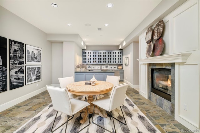 5425 S University Blvd, Greenwood Village, CO 80121 - dining area with stone tile floors, a tiled fireplace, recessed lighting, and baseboards