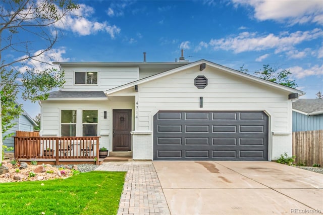 4714 S Simms Ct, Morrison, CO 80465 - view of front of home featuring an attached garage, concrete driveway, a shingled roof, and a wooden deck