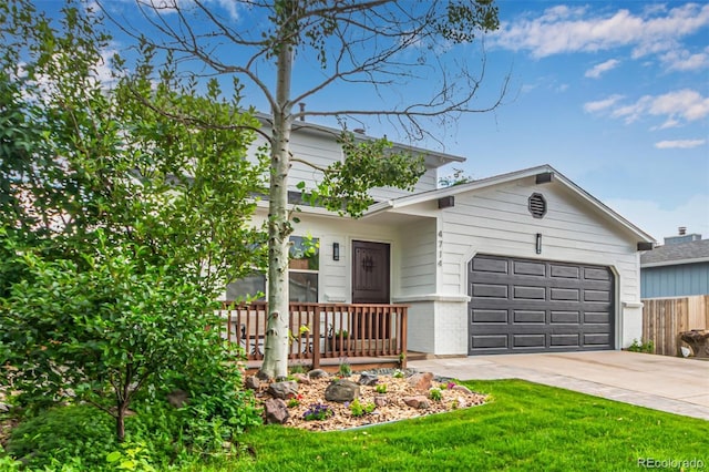 4714 S Simms Ct, Morrison, CO 80465 - view of front facade featuring an attached garage, driveway, brick siding, and a front yard