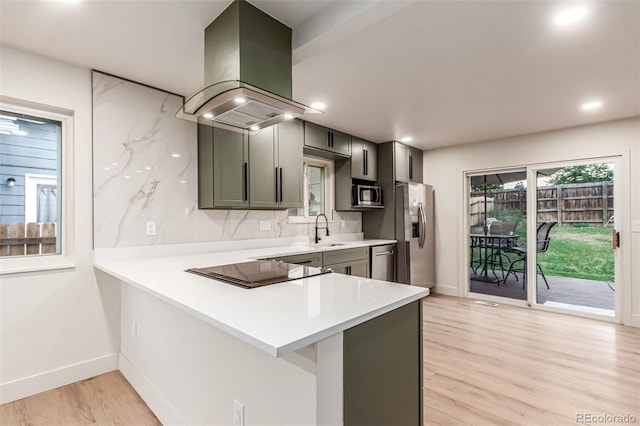 4714 S Simms Ct, Morrison, CO 80465 - kitchen with island exhaust hood, stainless steel appliances, light countertops, light wood finished floors, and recessed lighting