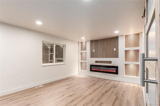 4714 S Simms Ct, Morrison, CO 80465 - unfurnished living room featuring wood finished floors, recessed lighting, and a glass covered fireplace