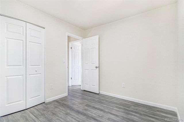 18751 E Mexico Ave, Aurora, CO 80017 - unfurnished bedroom with wood finished floors and a closet