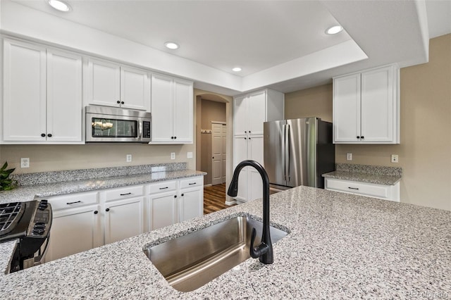 8216 Mahogany Wood Ct, Colorado Springs, CO 80927 - kitchen featuring stainless steel appliances, a sink, white cabinets, recessed lighting, and light stone countertops