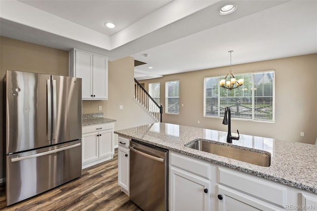8216 Mahogany Wood Ct, Colorado Springs, CO 80927 - kitchen with stainless steel appliances, a sink, white cabinets, dark wood finished floors, and plenty of natural light