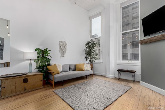 living area with baseboards and hardwood / wood-style flooring