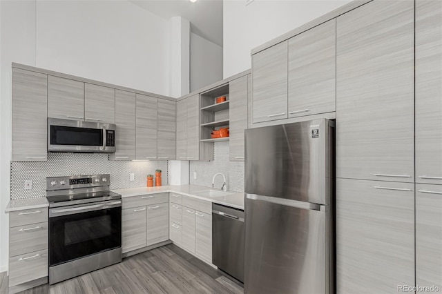 kitchen featuring open shelves, stainless steel appliances, modern cabinets, and decorative backsplash