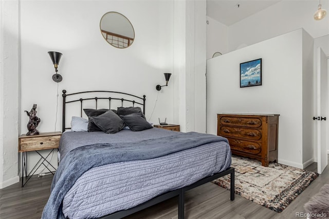 bedroom with baseboards and wood finished floors