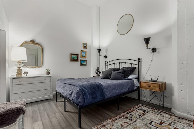 bedroom featuring baseboards and wood finished floors