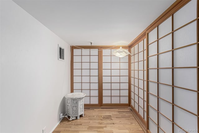 unfurnished room with visible vents and light wood finished floors