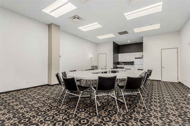 carpeted dining space with visible vents and baseboards