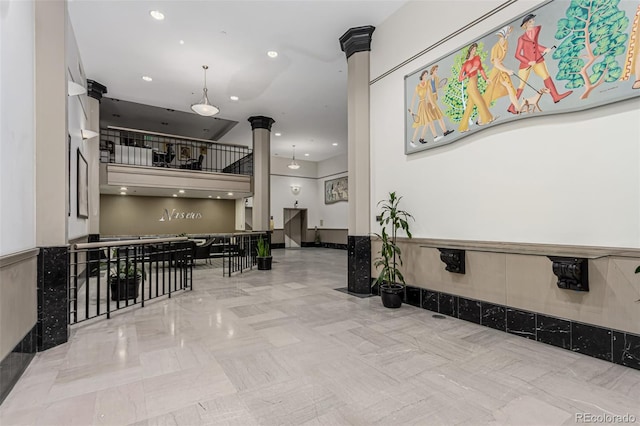 hallway with recessed lighting and decorative columns