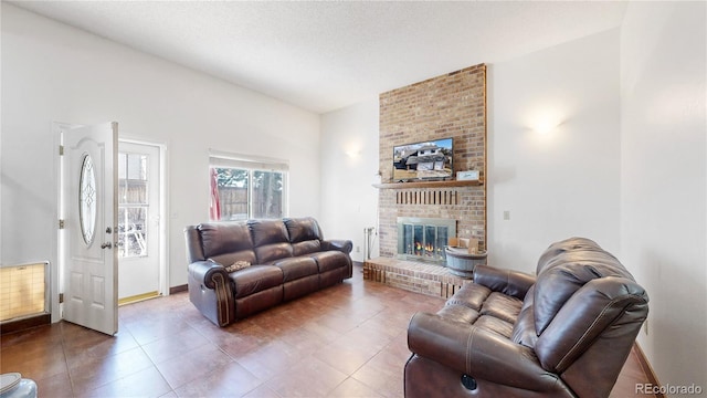 living room with dark tile patterned flooring, a textured ceiling, and a brick fireplace