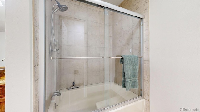 bathroom with bath / shower combo with glass door