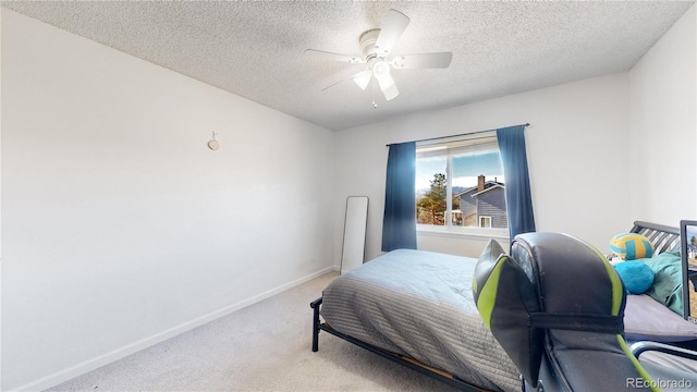 carpeted bedroom featuring a textured ceiling and ceiling fan