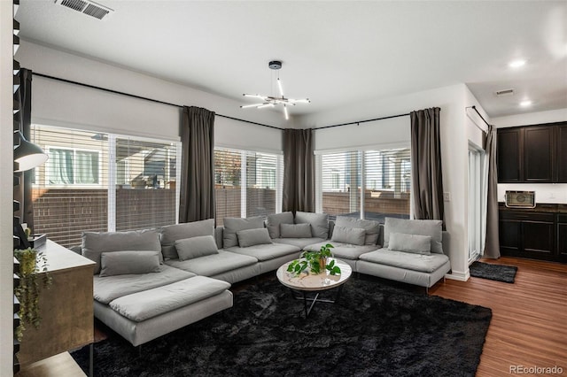 living room with hardwood / wood-style floors and an inviting chandelier