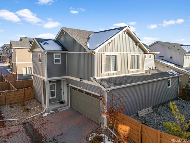 10226 Worchester St, Commerce City, CO 80022 - view of front facade featuring board and batten siding, decorative driveway, roof with shingles, fence, and an attached garage