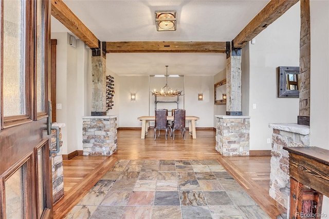 foyer entrance with a chandelier, beam ceiling, decorative columns, and hardwood / wood-style floors