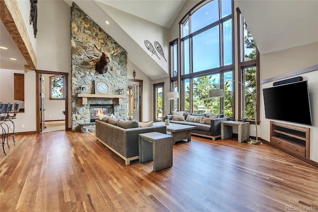 living room featuring a fireplace, hardwood / wood-style flooring, and high vaulted ceiling