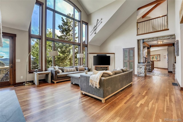 living room with a towering ceiling and wood-type flooring