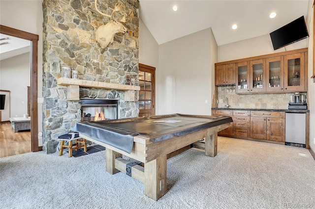 rec room with light carpet, high vaulted ceiling, a stone fireplace, sink, and pool table