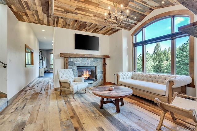 living room with a notable chandelier, a healthy amount of sunlight, a stone fireplace, and wood ceiling