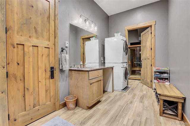 bathroom featuring hardwood / wood-style floors, vanity, and stacked washer / drying machine