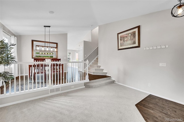 10571 Garfield St, Thornton, CO 80233 - staircase featuring lofted ceiling, baseboards, a chandelier, and carpet flooring