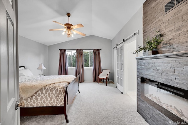10571 Garfield St, Thornton, CO 80233 - carpeted bedroom with a barn door, vaulted ceiling, ceiling fan, baseboards, and a stone fireplace