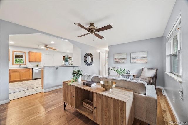 6327 Fenton St, Arvada, CO 80003 - living area featuring a ceiling fan, light wood-style floors, and healthy amount of natural light