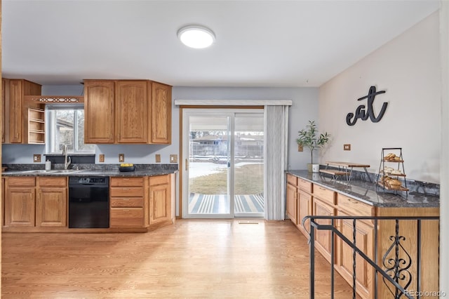 kitchen featuring dark stone countertops, sink, light hardwood / wood-style flooring, and dishwasher