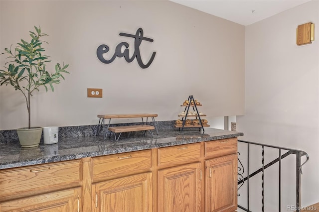 interior space with dark stone countertops and light brown cabinets