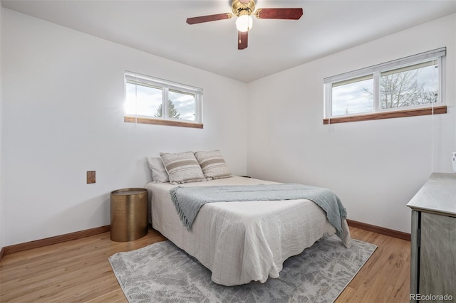 bedroom with multiple windows, light hardwood / wood-style flooring, and ceiling fan