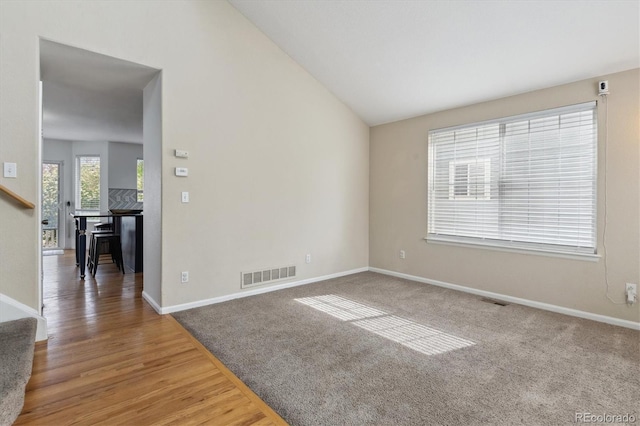 10517 Madison St, Thornton, CO 80233 - carpeted spare room with stairway, lofted ceiling, baseboards, and wood finished floors