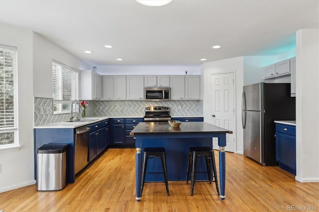 10517 Madison St, Thornton, CO 80233 - kitchen with stainless steel appliances, a sink, blue cabinets, backsplash, and recessed lighting