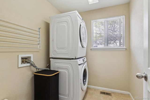 10517 Madison St, Thornton, CO 80233 - laundry room with stacked washing machine and dryer, baseboards, and light tile patterned flooring
