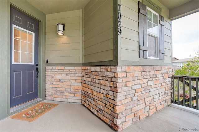 7029 Sagerock St, Castle Pines, CO 80108 - view of exterior entry with covered porch and brick siding