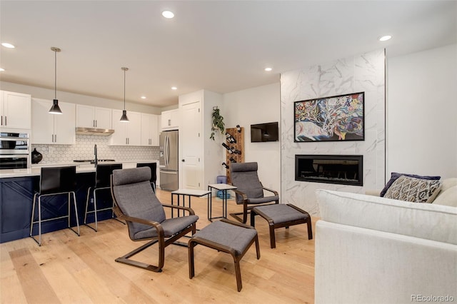 7029 Sagerock St, Castle Pines, CO 80108 - living area with light wood-type flooring, a premium fireplace, and recessed lighting